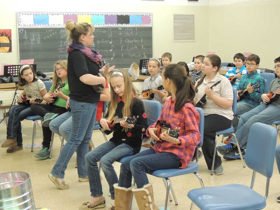 STRUM — Students in Mrs. Laureti’s fifth grade class receive instructions from music teacher, Ms. Kate Zimmerman. The students learned where to correctly place their fingers on the ukuleles as well as how to play many chords. I have color coded the chords for all students so that they are able to quickly locate where their fingers need to go, Zimmerman said. They are almost instantly successful because of this.
