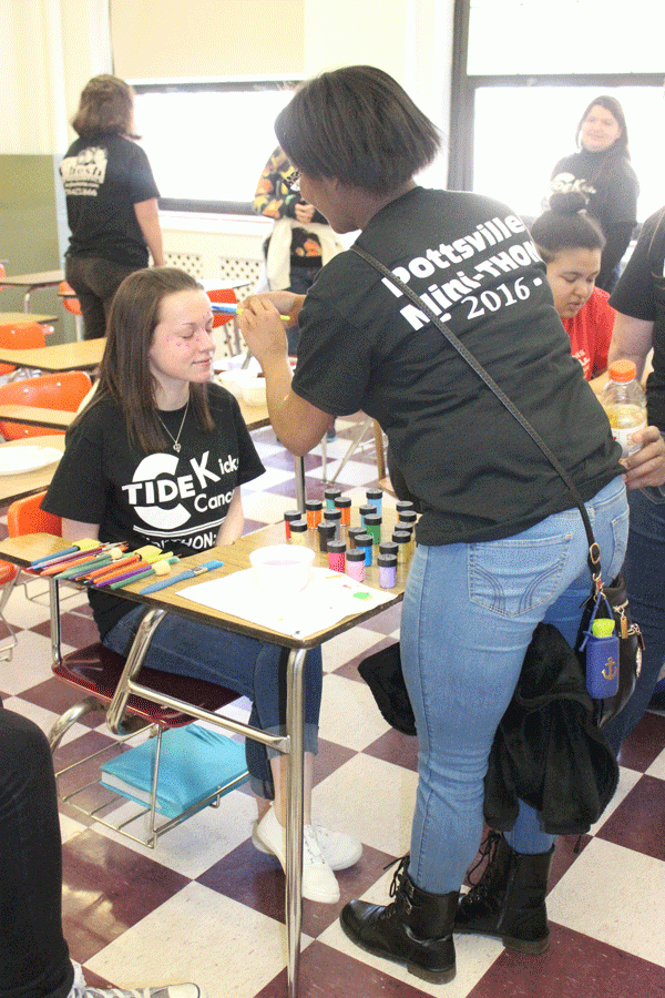 PREPARE— Senior Shaniya Walker paints senior Elizabeth Walters’ face at the second annual Mini-THON. This year’s Mini-THON raised almost five thousand dollars. “Mini-THON is important to me because it creates a peace of mind for the children’s families knowing costs are being covered. We sold quarter zips and T-shirts to raise extra money,” Walters said.