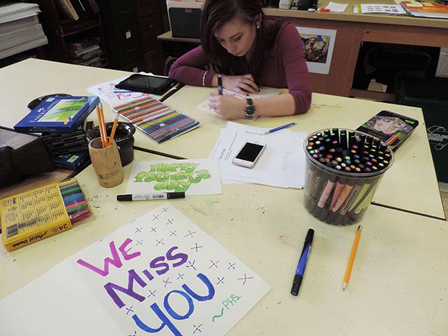 While sophomore Abigale Williams creates a card, art supplies cover the table. Sketch Club members delivered cards to Ms. Jacqueline Mitchell, science teacher, for the holiday season to brighten her day. “We have so many talented students in Sketch Club, and this is a great opportunity for them to use their abilities to help others,” Mrs. Sara Arnold, Sketch Club adviser, said. 