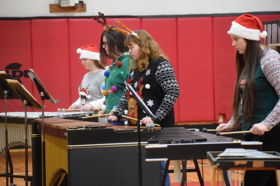 Victoria Oswald and musicians play for students at JSC. The ensemble members put on festive clothing and played Christmas music for third and fourth grade students. Junior Wesley Evans said, I enjoyed going down to the elementary school to see some of my old teachers and play for the little kids. 