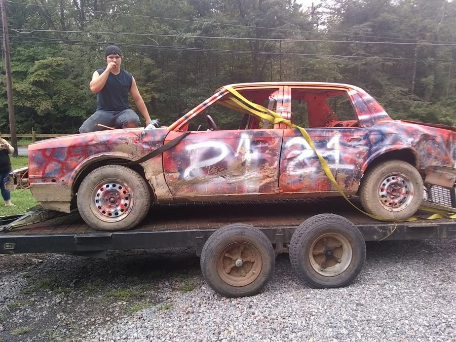 Senior+Noah+Brittenburg+poses+with+his+demolition+racing+car.