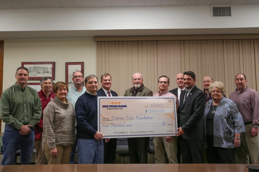 Members of the Crimson Tide Foundation pose with the $5,000 check from Mid Penn Bank. From left back row: Cory Holobetz, Ned Connors, Pete Joyce, Dr. Jeffrey Zwiebel, Craig Shields, Vince Wychunas, Jim Brennan of Mid Penn Bank, Adrian Portland, Bob Dusel Jr.—front row left Lillian Hobbs, John Liddle, Keith Kirby of Mid Penn Bank, Kathy Zwiebel