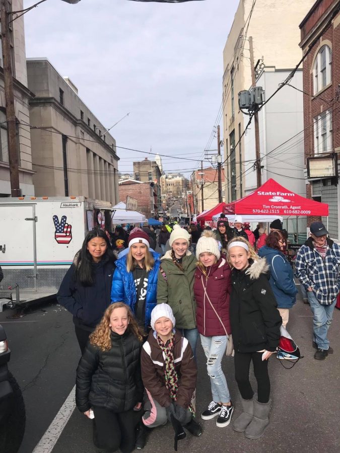 (Top Row From left to right) Faith Toothacker, Samara Reedy, Brenna McGowan, Abbey  Garrity (Bottom row left to right) Madison Thomas, and Emma Seiger stand in front of local booths at the 2019 Winterfest celebration. Since 2017, Winterfest has brought a large group of people that participate in the activities. “I think my favorite part about Winterfest was seeing what Yuengling had to offer,” said Eighth grader Madison Eroh.