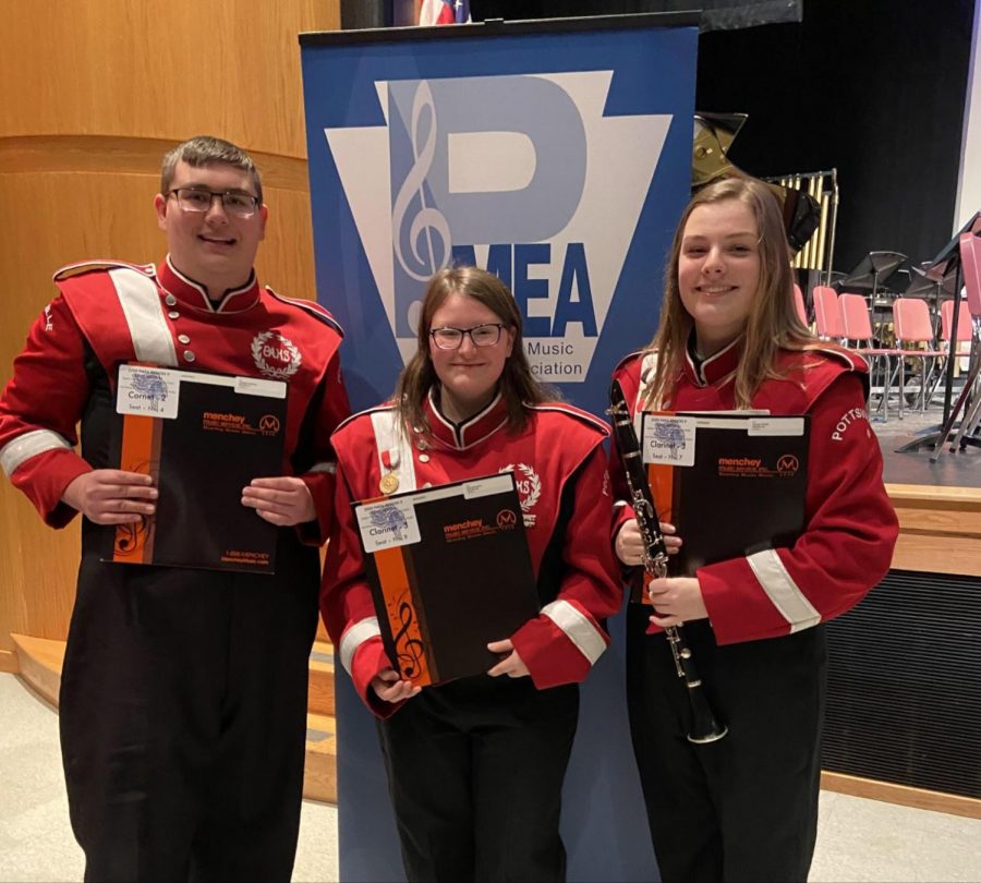 (From Left to right) Christian Honicker, Grace Mongrain, and Vanessa Biddle stand in front of the P.M.E.A District Band Concert sign. All three students qualified to Regional Band after their successful efforts at District Band. Honicker said, “I wasn’t expecting to get this far. I guess it goes to show how far we have come as musicians.” 