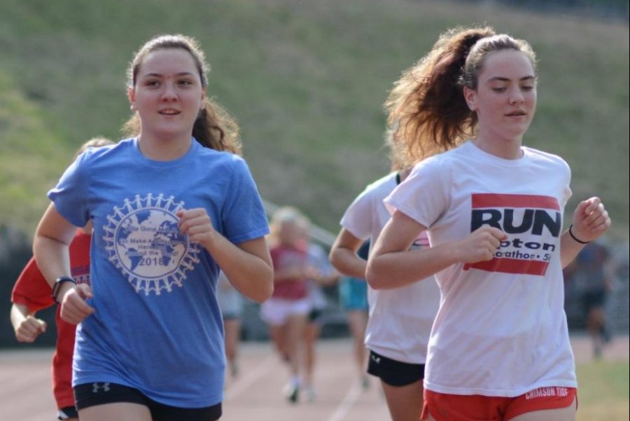 Haily Mervine and her sister Paige Mervine warm up at cross country practice. The two sisters trained hard at practice so they are prepared for their meet. Haily Mervine said, “When I first started running, I tried to pace myself off of my older sister, Paige, who is also a runner with me. 