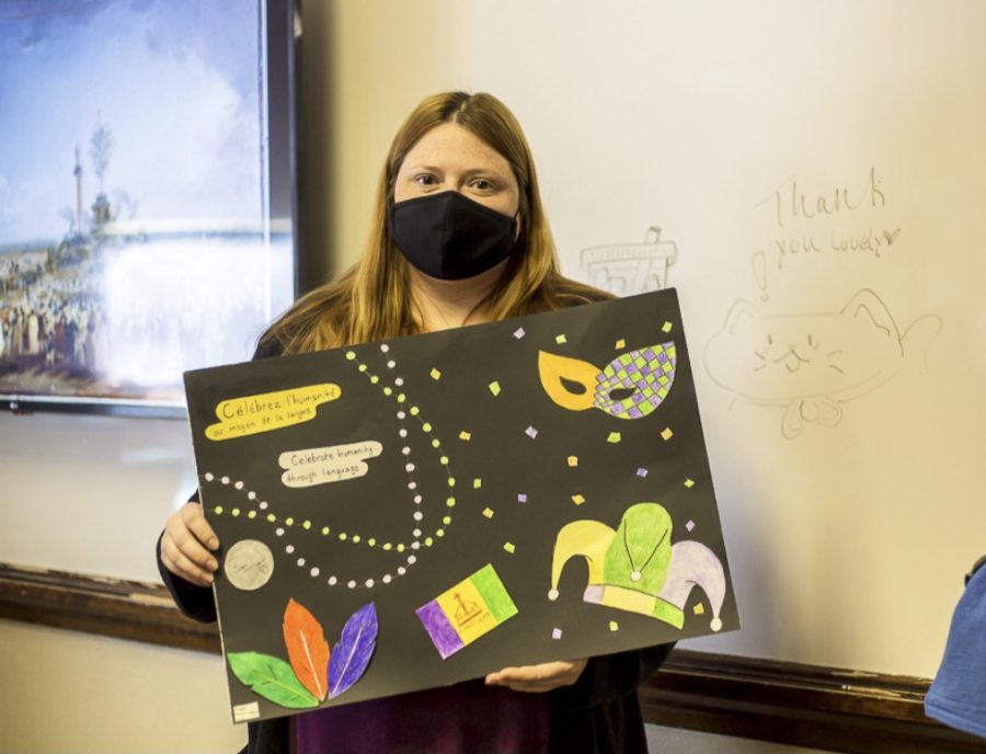 Mrs. Stiles poses with a poster from a student for the poster contest. Stiles is the current advisor for Foreign Language Club. “The poster contest challenges students to come up with a creative way to represent the year’s theme,” said Mrs. Nicole Stiles.