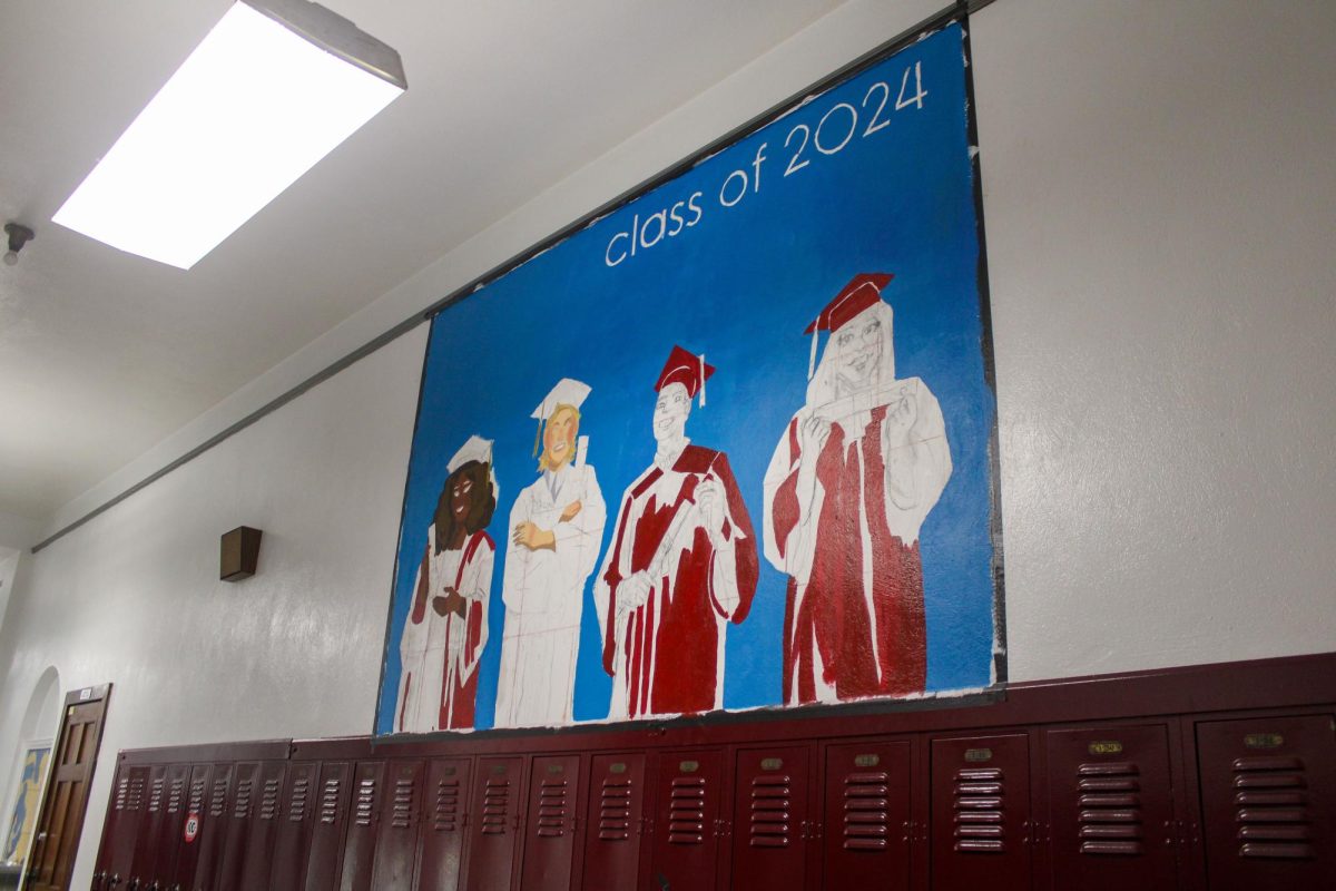 Finishing+touches+on+the+senior+mural+are+almost+done.+%E2%80%9CThe+mural+I+designed+is+based+on+the+Weezer+album+cover.+Originally+it+was+going+to+be+a+joke%2C+but+we+all+grew+to+love+how+it+represented+our+school+and+how+it+relates+to+the+role+of+pop+culture+in+our+generation.+senior+Cade+Lubinsky+said.+