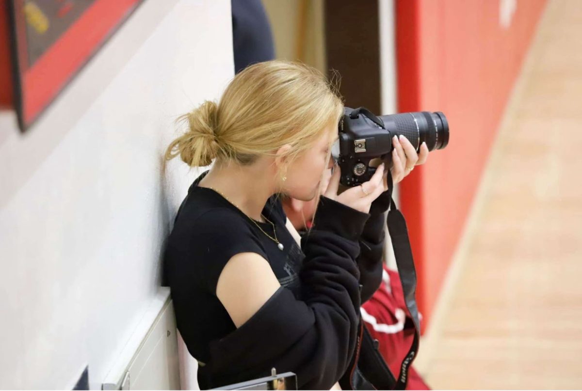 Senior Cami Quirin Morris takes pictures of the basketball boy players doing their warmups. She posts pictures of them on her Instagram for everyone to see.
