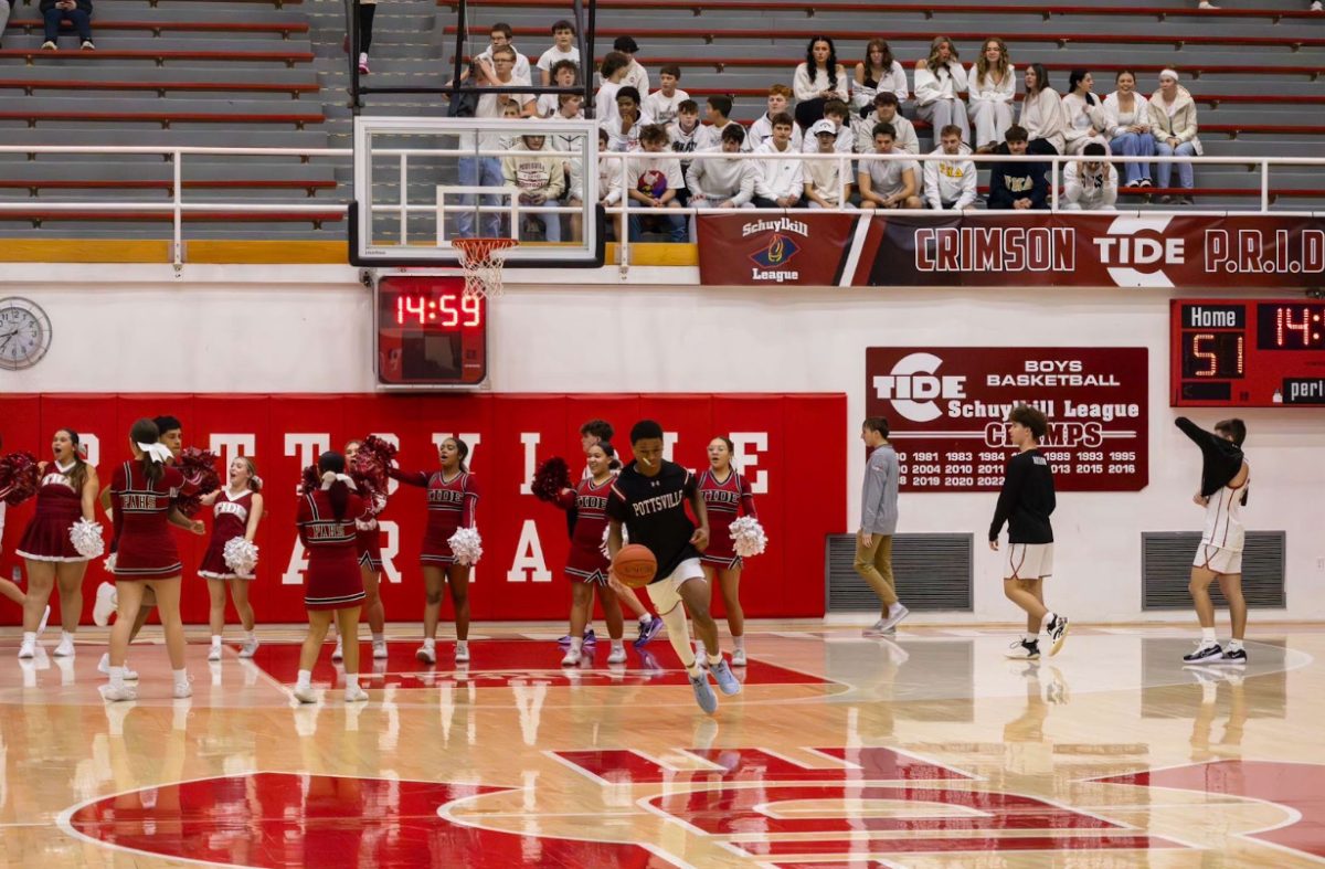 Senior Derek Watkins leads the Tide out to warm up for their game. Warm ups consist of shooting, dribbling, and passing drills to gear up for games. 
