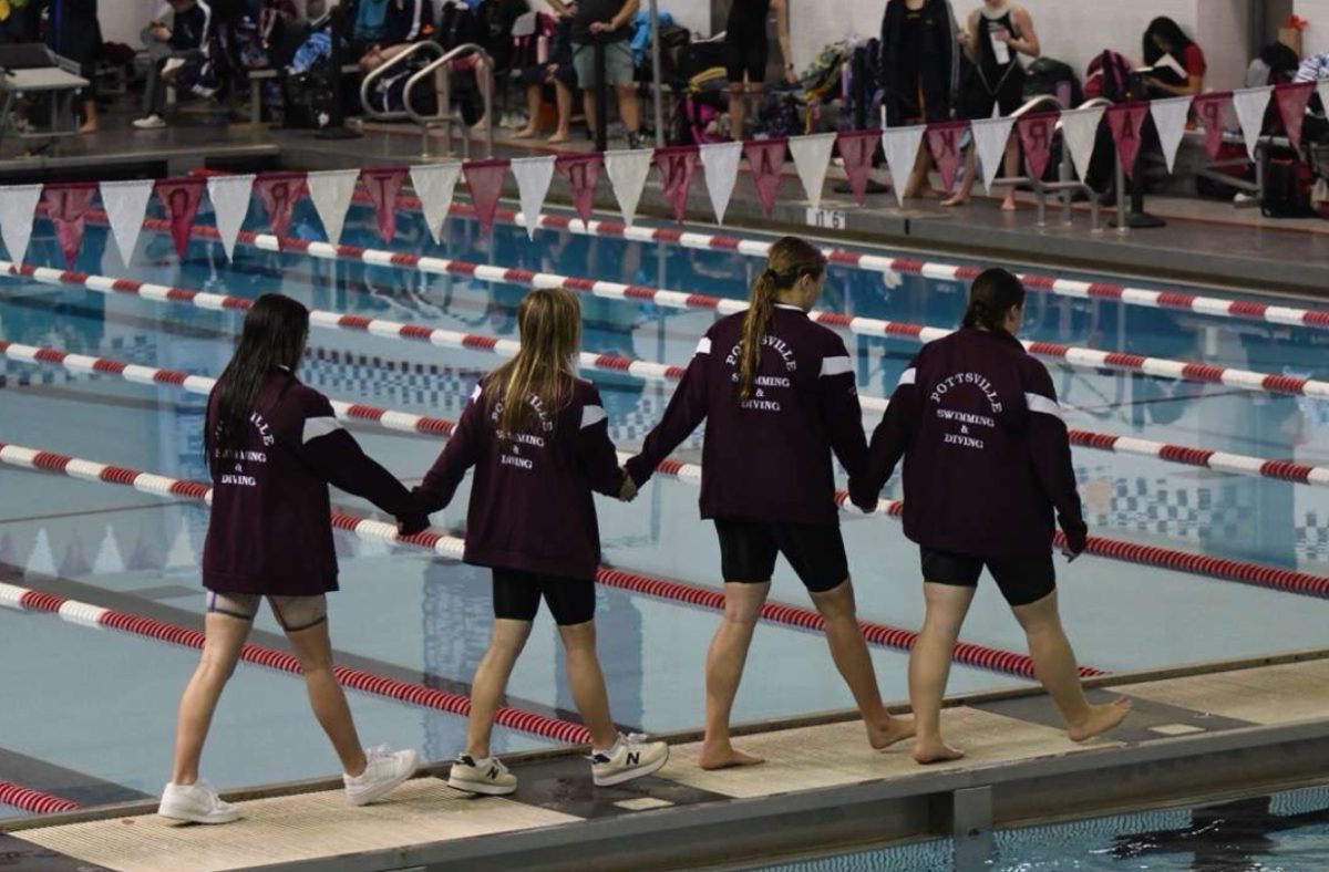 Gianna LaSelva (10), Lizzy Martinko (12), Adalia LaSelva (12), and Jill Horvath (12), are walking to get their medals at Districts. The 200 free relay team achieved greatness at their last event of the year together. 