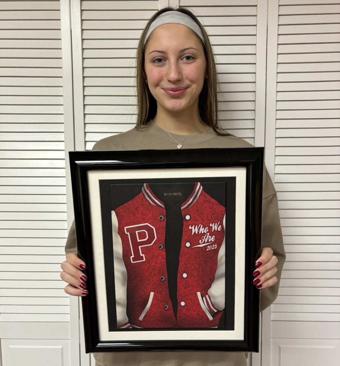 Anna Burke is holding the yearbook cover for the 2024-2025 school year. She is a part of the publicity section of Publications which focuses on the social media aspect of the making of the yearbook. 
