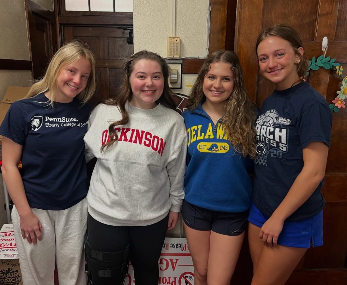 Lizzy Martinko, Elena Holden, Julie Szeliga, and Lauren Kelly all pose with their colleges’ shirts on. National Decision Day was on May 1, and most, if not every, senior has committed. 
